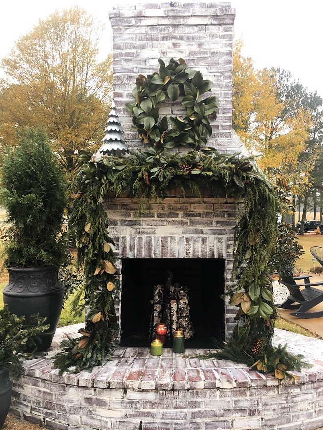 Whitewashed Brick Fireplace Outdoor Whitewashed Brick Fireplace decorated for Christmas with Magnolia Wreath and Magnolia and Fir garland #Fireplace #whitewashedbrick #whitewashedbrickfireplace #outdoorfireplace #Christmas