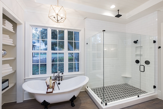 Frameless glass shower with hexagonal black and white tiled floor