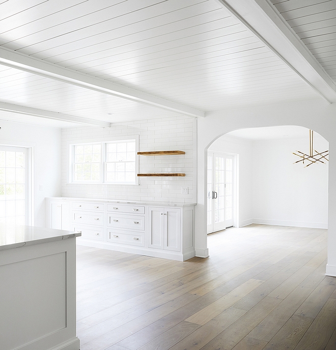 White kitchen with matte hadrwood flooring Ceiling is Tongue and groove with beams painted in Benjamin Moore Chantilly Lace #Whitekitchen #mattehadrwoodflooring #hadrwoodflooring #Ceiling #Tongueandgrooveceiling #beamsceing #paintedbeams #BenjaminMooreChantillyLace