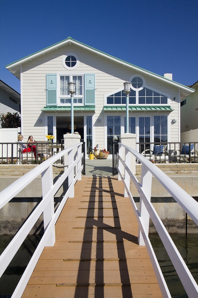 Beach house with turquoise shutters painted in Benjamin Moore wythe blue and seafoam metal roof Coastal vibes