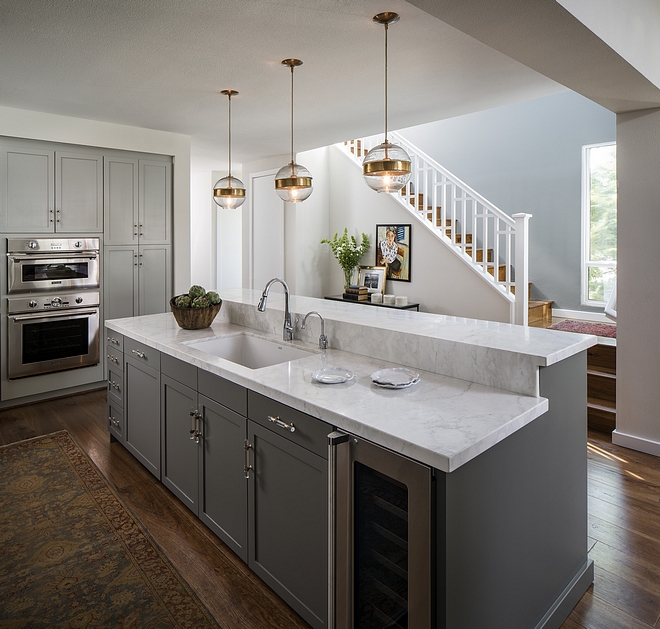 Kitchen island features bar-height counters with Crema Delicato honed marble countertop Sherwin Williams Porpoise #Kitchenisland #SherwinWilliamsPorpoise