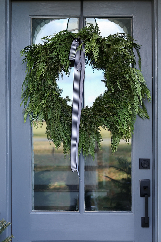 Christmas Decor A natural wreath with a simple stripped ribbon adds a festive yet subtle Christmas feel to the front entry #Christmasdecor #naturalchristmas #naturalchristmasdecor