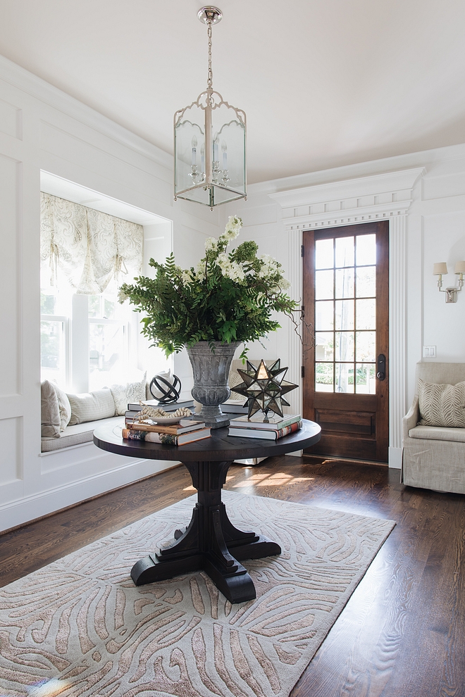 Traditional Foyer Traditional Foyer with round table, rug, window-seat, medium Red Oak Hardwood flooring and Visual Comfort lantern pendant light Traditional Foyer #TraditionalFoyer #traditionalinteriors #foyer