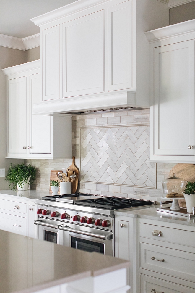 White kitchen inset cabinet painted in White Dove by Benjamin Moore with Limestone blacksplash tile in herringbone pattern above range White kitchen inset cabinet painted in White Dove by Benjamin Moore #Whitekitchen #insetcabinet #kitcheninsetcabinet #WhiteDovebyBenjaminMoore