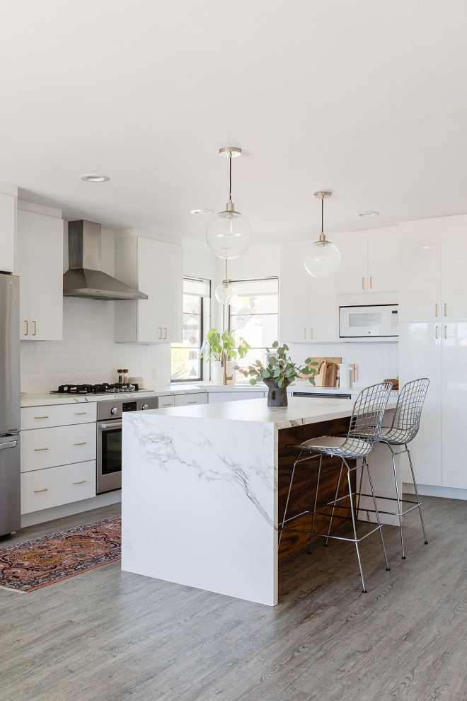 Waterfall countertop We used a material called Dekton for the countertops. It’s super durable and has the look of a marble but definitely not the feel or etching potential. We absolutely love it as a marble or quartz alternative. The island itself is also made from the Dekton “Aura”. We stained walnut for the wood paneling. I think it gives it a warm contrast of color and texture #countertop #marblealternative