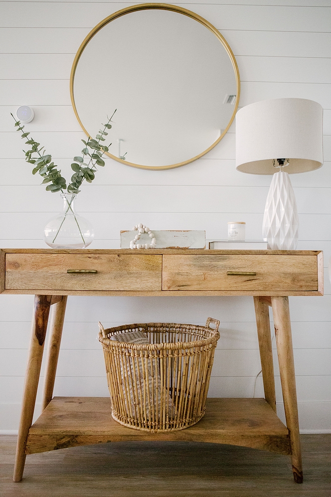 Foyer decor with mid-century modern console table, textured table lamp, faux greenery in clear glass vase and round brass mirror #foyer #Foyerdecor #midcentury #modernconsoletable #texturedtablelamp #fauxgreenery #roundbrassmirror