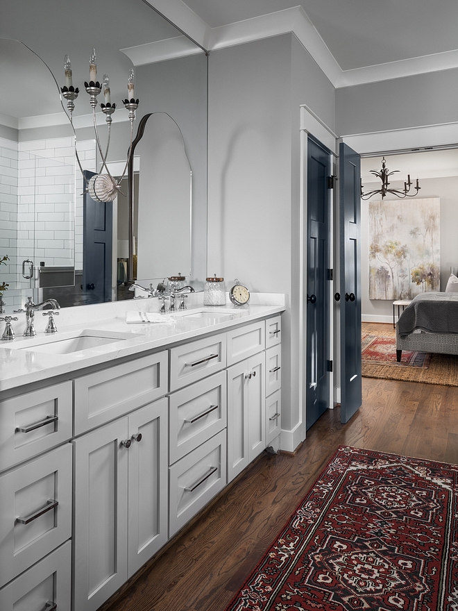 Master bathroom cabinets feature shaker style doors and drawers. Paint color is Sherwin Williams Mindful Gray. Arched mirrors are installed over a large custom mirror to give a layered feel to it #bathroomcabinet #bathroommirrors
