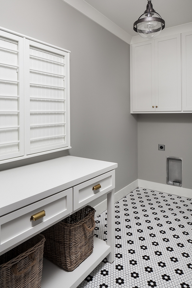 Laundry Room Located upstairs, this laundry room features a custom folding cabinet/island and retro-style mosaic floor tile #LaundryRoom #foldingtable #foldingcabinet #retrotile