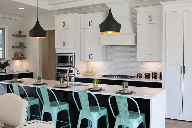 Kitchen This kitchen features white upper cabinets and black lower cabinets Notice the waterfall-edge island and the floating shelves flanking the window #kitchen