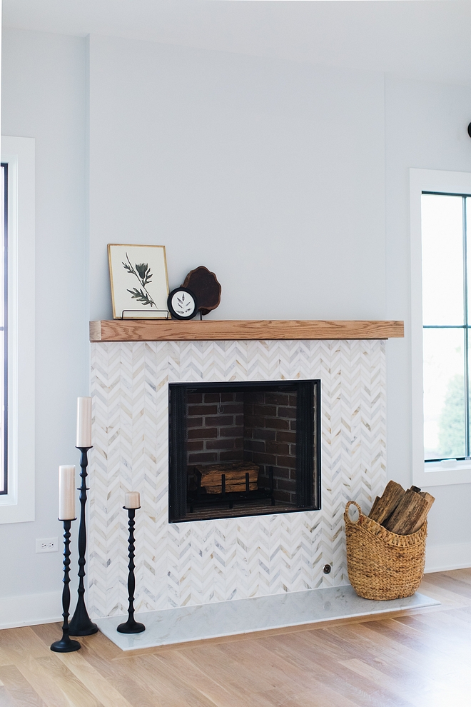 Fireplace Tile Fireplace chevron marble mosaic tile A fireplace with chevron marble mosaic tile and beam mantel is the focal point of the family room #fireplace #fireplacetile #chevronmarbletile #mosaictile