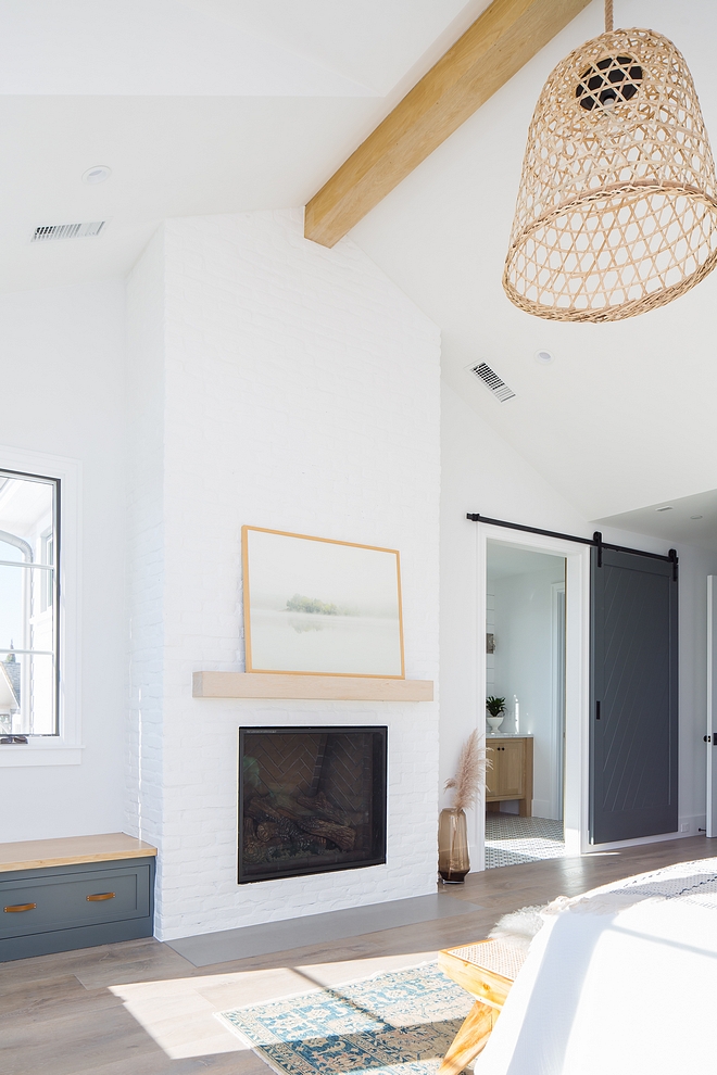 The master bedroom features a fireplace with white matte brick with gray matte concrete hearth and White oak mantel