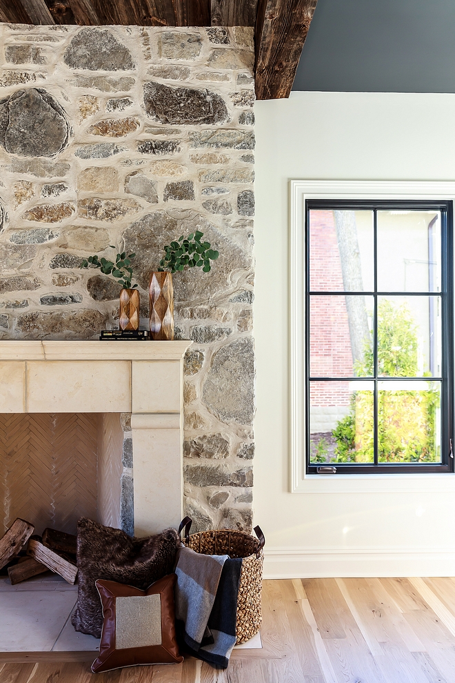 Stone Fireplace This dramatic stone fireplace creates quite the focal point in this family room Stone Fireplace with reclaimed wood beamed ceiling and Limenstone mantel #stonefireplace #fireplace #limestonemantel