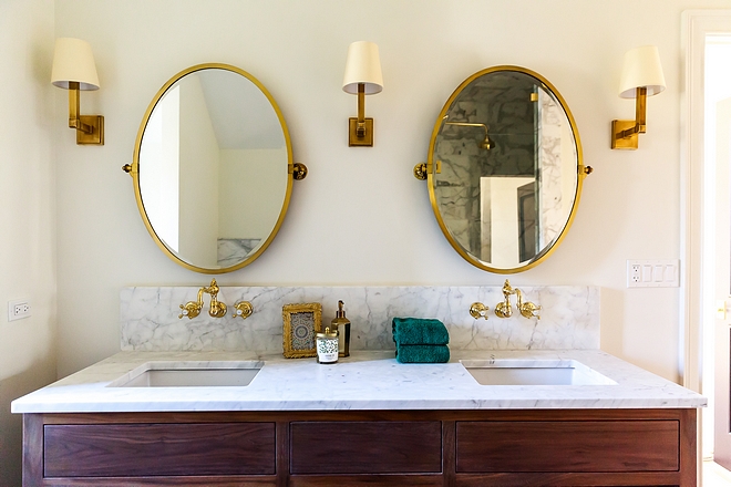 Bathroom Brass Mirror Bathroom with oval brass mirrors over brass mounted faucets, Waterworks Julia Wall Mounted Faucet #bathroom #brassmirror #bathroomirror #ovalmirror