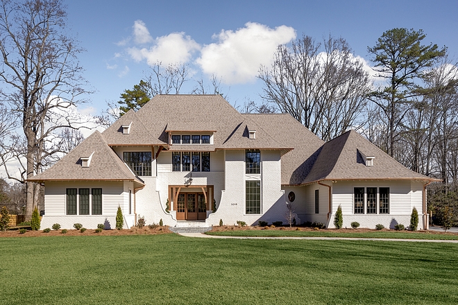 New Home Design This home has a sense of symmetry and balance, without being 100% symmetrical, which accomplishes our modern-traditional style goal. The wing walls are a must in all of our home designs, if feasible, and we went all out with them here The two wing walls on opposing sides of the front door act to guide your eye to the entry of the home, making it that much more inviting #NewHomes #HomeDesign #NewHomeDesign