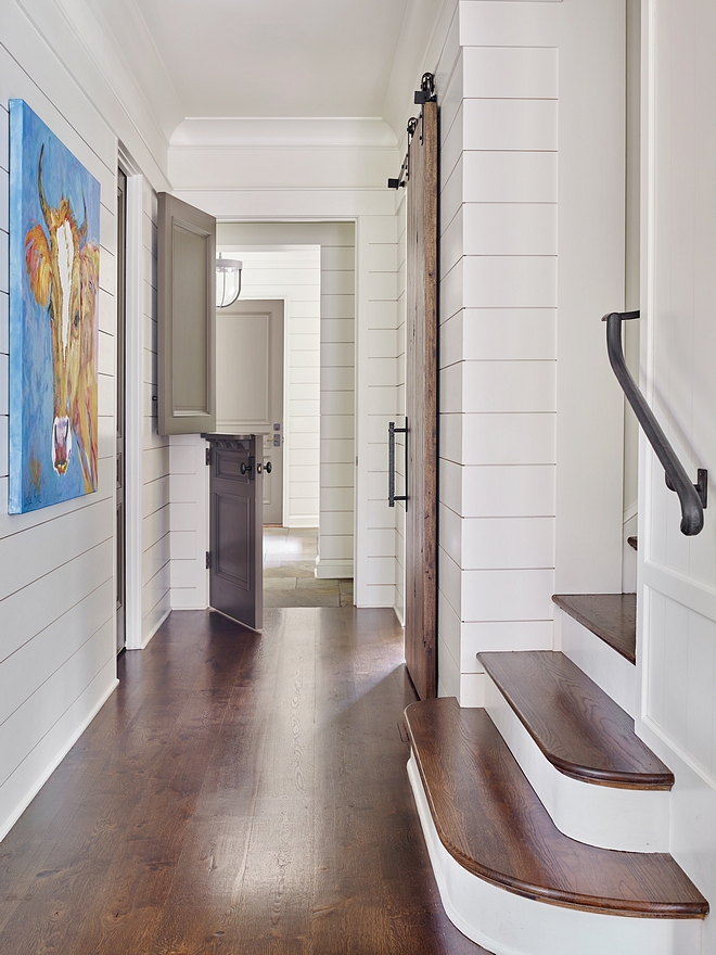 Hardwood Floors Throughout the Home is Oak Notice the stunning staircase with radiused treads and the grey Dutch-door leading to the mudroom Shiplap is painted in Benjamin Moore White Dove #hardwoodflooring #oak #shiplap #barndoor #shiplap #Benjaminmoore #Benjaminmoorewhitedove #Dutchdoors #staircase #radiusedtreads #staircasetreds