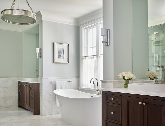 Bathroom paint color Benjamin Moore Horizon Wall paint color is Benjamin Moore Horizon A freestanding tub is tucked into a nook located between the vanities #BenjaminMooreHorizon