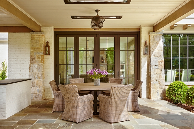 Flanked by stone columns, the retractable patio doors open to an inviting covered patio with outdoor kitchen Floor tile is Bluestone #patio #bluestone #outdoor #oudtdoors #outdoorkitchen