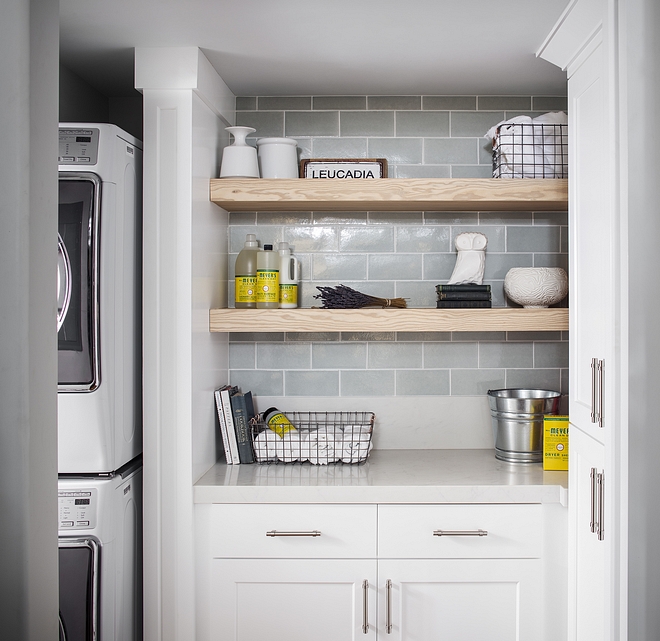 Laundry room floating shelves over crackled subway tile backsplash Laundry room features stacked washer/dryer, which is a space saver, and floating shelves over crackled subway tile backsplash #laundryroom #floatingshelves #laudryroombacksplash #laundryroomtile #crackledsubwaytile #subwaytile #laundryrooms