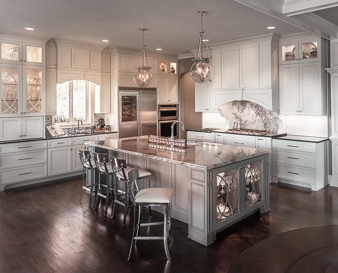 Kitchen Layout This traditional kitchen features a large island in the center with the kitchen hood located right across of the island sink. A wet bar is located on the left and a custom hutch is located on the opposite side of the room, close to the breakfast area #kitchenlayout #kitchen #wetbar #kitchenhutch #kicthen #layout