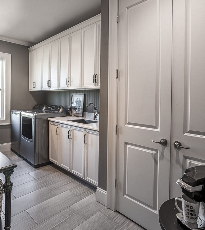 White and grey laundry room with 12x24 floor tile and beadboard backsplash Wall paint color is Martha Stewart MSL266 Cement Gray #laundryroom #MarthaStewart