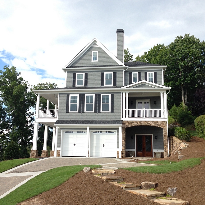 The exterior of this home features grey shingles, black shutters and stacked stone Home Exterior The exterior of this home features grey shingles, black shutters and stacked stone #exterior #home #siding #greyshingles #blackshutters #stackedstone