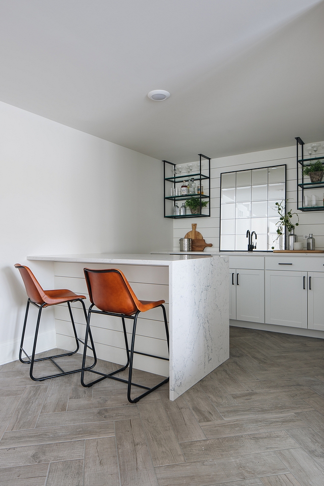 Farmhouse Bar Basement with farmhouse bar This farmhouse basement bar features a peninsula with Caesarstone White Attica waterfall edge countertop #farmhousebar #bar #basementbar #basement