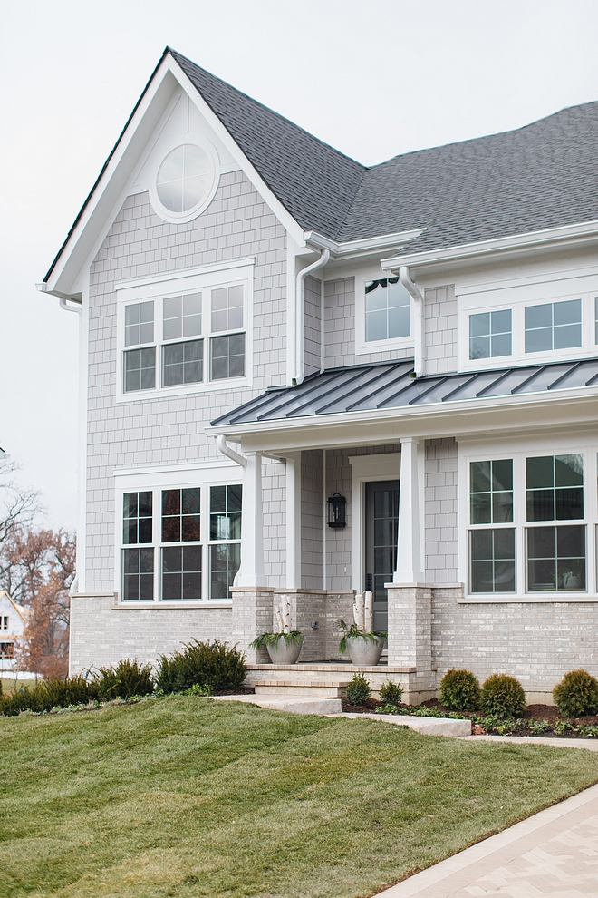 Exterior siding combination of grey shingles, white trim, white Craftsman style porch colums and brick accent Classic Exterior with light grey shingles and brick #Exterior #siding #greyshingles #whitetrim #Craftsmanstyleporchcolums #Craftsmancolumn #porch #brickexterior #brick #exteriorsiding