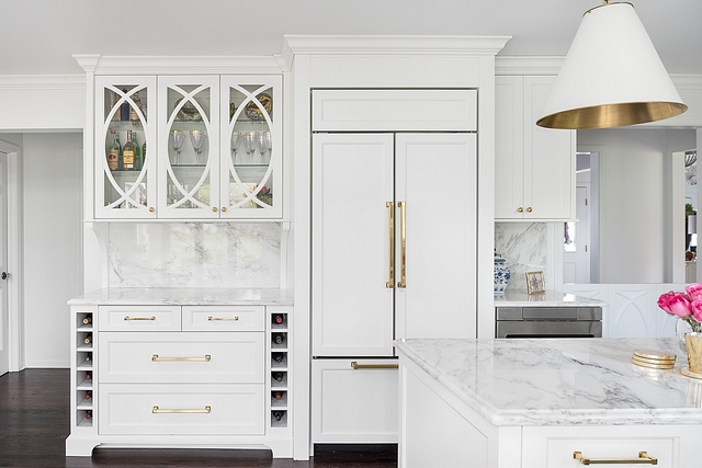 Kitchen Bar Cabinet A paneled refrigerator is flanked by a bar cabinet with eclipse mullion doors and a small cabinet with microwave drawer #kitchen #bar #cabinet #barcabinet #kitchenbar
