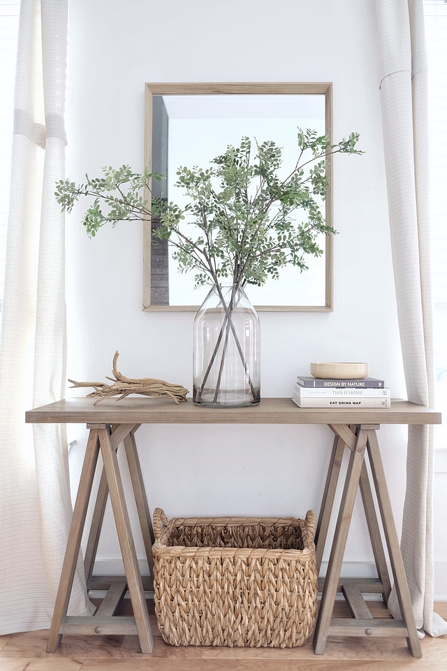 Coastal Farmhouse Foyer Console Table Wooden Mirror Woven Basket Glass Vase with Greenery and driftwood #CoastalFarmhouse #Foyer #ConsoleTable #WoodenMirror #WovenBasket #GlassVase #Greenery #driftwood