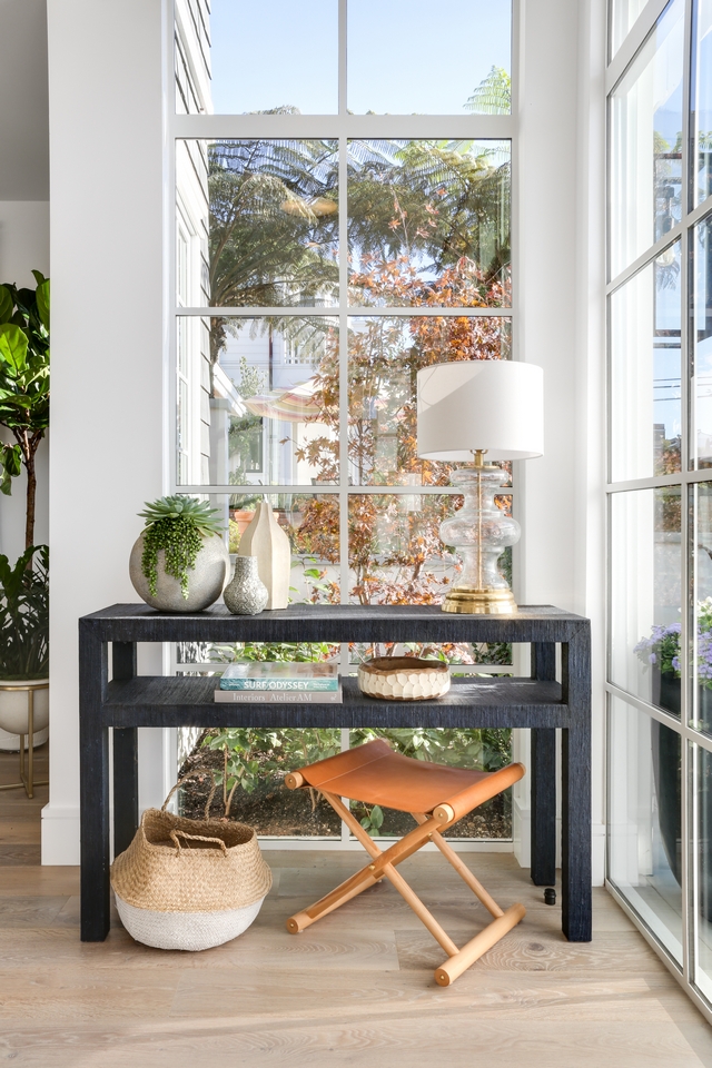 Raffia Console Table A pair of black raffia console tables add character while not obscuring the windows in this foyer #raffiaconsoletable #consoletable #raffiatable