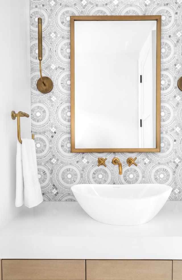 Powder room This powder room was designed to impress! I love the combination of the brass accents with the marble mosaic tile #Powderoom #mosaictile #brass