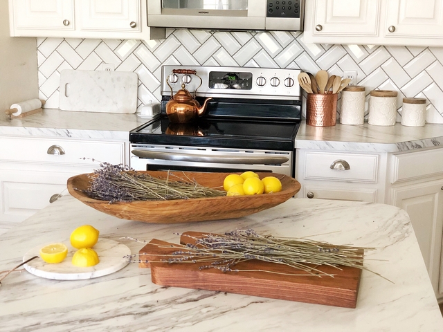 Backsplash is a subway tile with a beveled edge in a herringbone pattern The grout is light gray