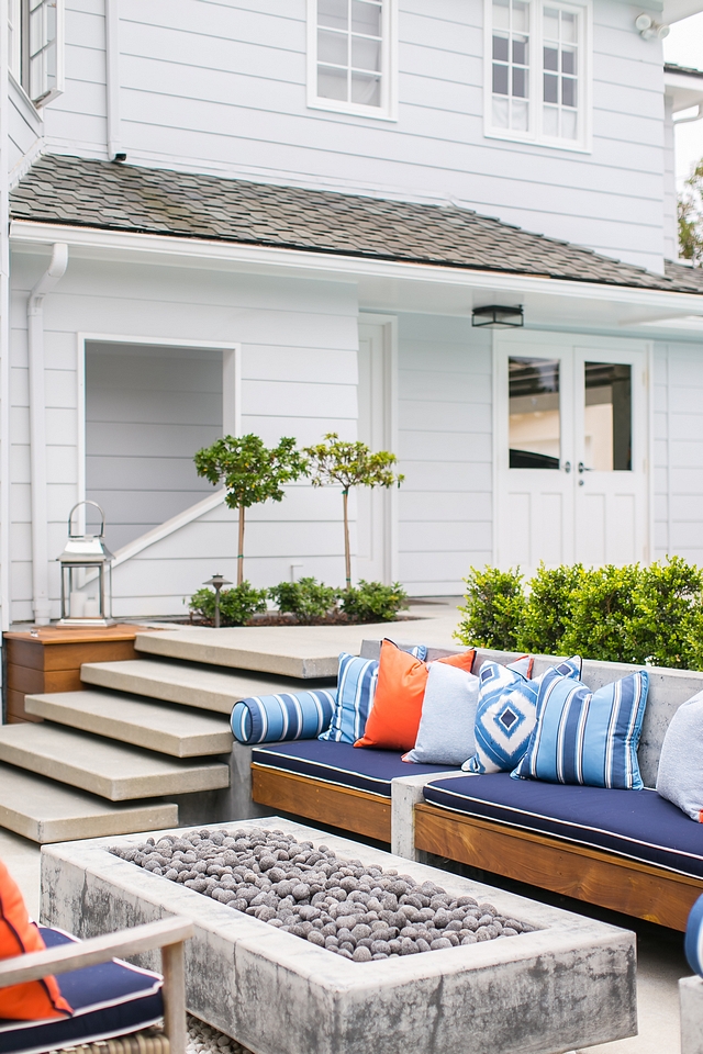 Outdoor lounge area with concrete built-in sofa and concrete firepit #outdoors #loungearea #concretesofa #concretefirepit