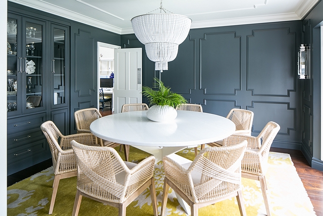 Dramatic dining room with charcoal Gray Wainscotting, white beaded chandelier, modern rope dining chairs and X Base white Round Dining Table #diningroom #darkwainscotting #homedecor #diningtable #xbasediningtable