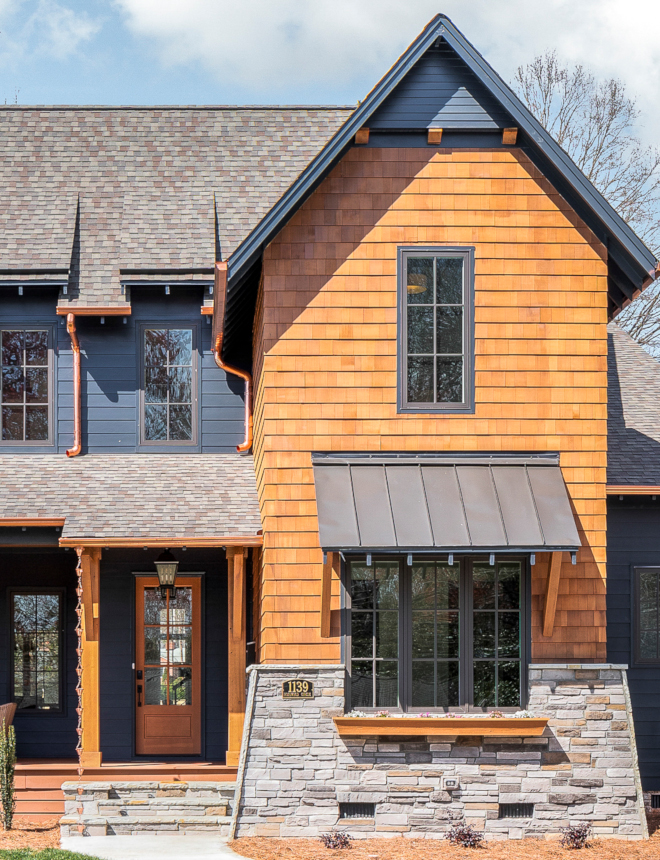 Dark Exterior Paint Color To lighten the facade up a bit and to ensure a focal point of the design, we used cedar shake and a stacked stone wing wall to coat the gabled bump out. A window box adds a feeling of quaintness and homeliness. The shake, as well as cedar columns, a front door are all stained in Benjamin Moore Hidden Valley #cedarshake #stackedstone #DarkExteriorPaintColor