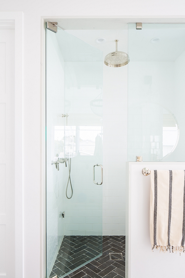 The shower features a white subway tile on walls and the same herringbone Blue limestone tile, also. I actually really like using the same floor tile in the entire bathroom because it makes the space feel larger and less busy