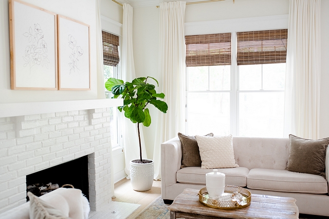 Layered windows with white linen curtains and bamboo shades To accentuate our tall ceilings and add drama to the design, I hung the curtains just below the crown molding #Layeredwindows #whitelinencurtains #bambooshades