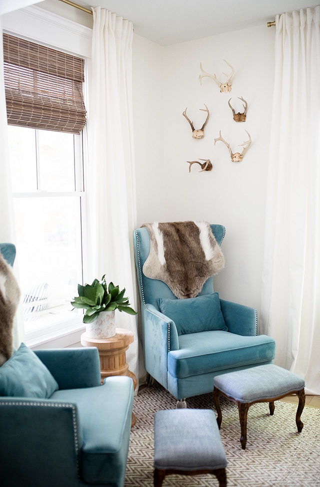 Study featuring a pair of blue velvet wingback chairs with acrylic feet and creamy white walls, painted in Sherwin Williams Alabaster #study #bluevelvetchairs #wingbackchair #sherwinwilliamsalabaster