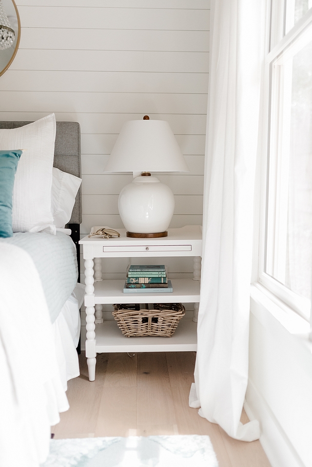 White nighstand Bedroom featuring white nighstand placed against a white shiplap wall and decorated with a white Ralph Lauren ceramic table lamp #Whitenighstand #Bedroom #nighstand #shiplap #RalphLauren #ceramictablelamp #tablelamp