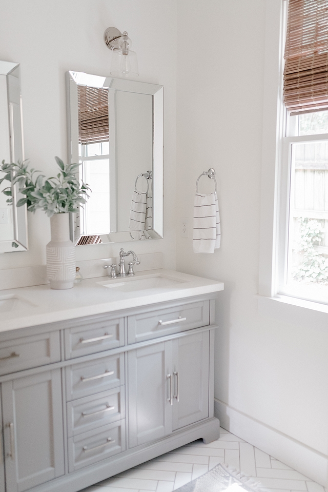 For our bathroom, we went with large white subway laid in a herringbone mosaic on the floor and a store bought grey vanity #bathroom #largesubwaytile #herringbonetile #greyvanity #bathroomvanity #storeboughtvanity #bathrooms