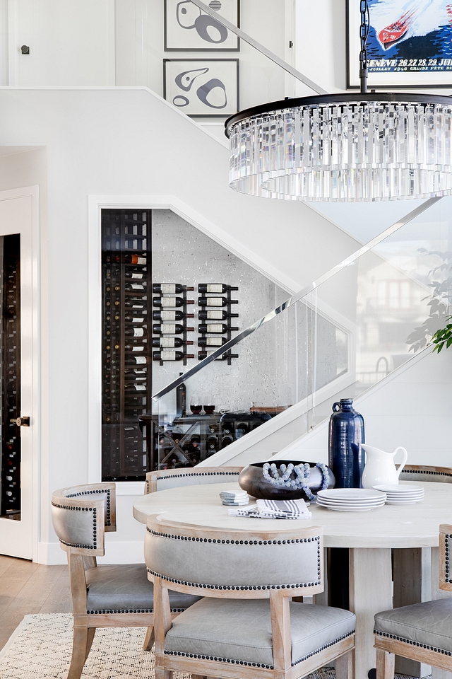 Winer Cellar Dining Room with Wine Cellar The dining room feels inviting with a round dining table and a comfy rug. Also notice the sleek staircase with glass railing and the beautiful wine cellar #winecellar #diningroom #glassrailing