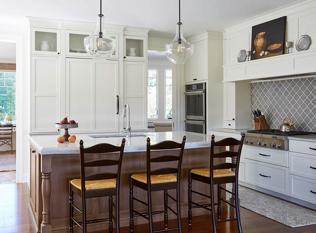 Classic white kitchen What a warm and inviting kitchen Classic white perimeter cabinets with shaker style doors contrast with a medium-stained wooden island #whitekitchen #classickitchen #interiordesign #warmwhitekitchen #kitchen #kitchenisland