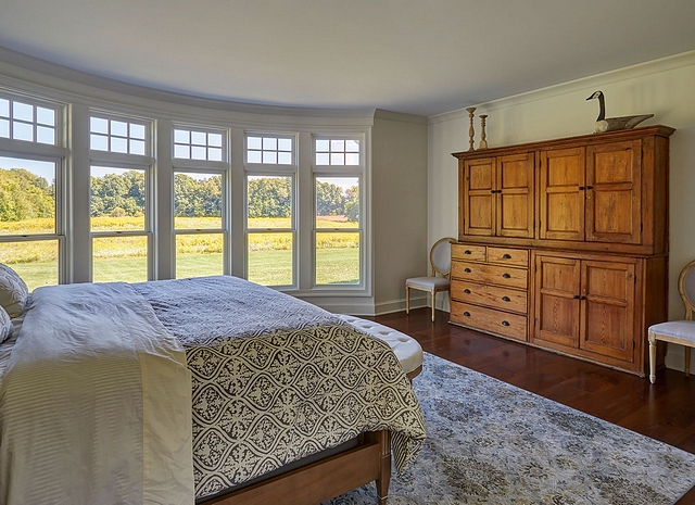 Master bedroom This inviting master bedroom a stunning curved wall of windows. Paint color is Sherwin Williams SW7014 Eider White in an Eggshell finish #masterbedroom #curvedwall