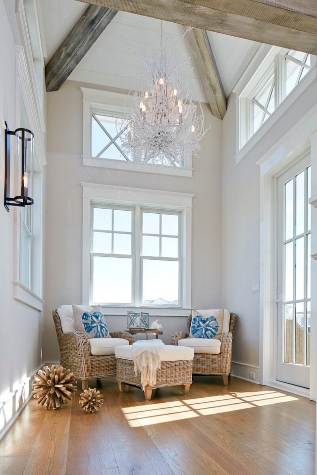 Small sitting room with tall ceiling featuring reclaimed beams, shiplap and a coastal white twig chandelier #sittingroom #smallspaces #ceilingbeams #coastalchandelier #twigchandelier #chandelier