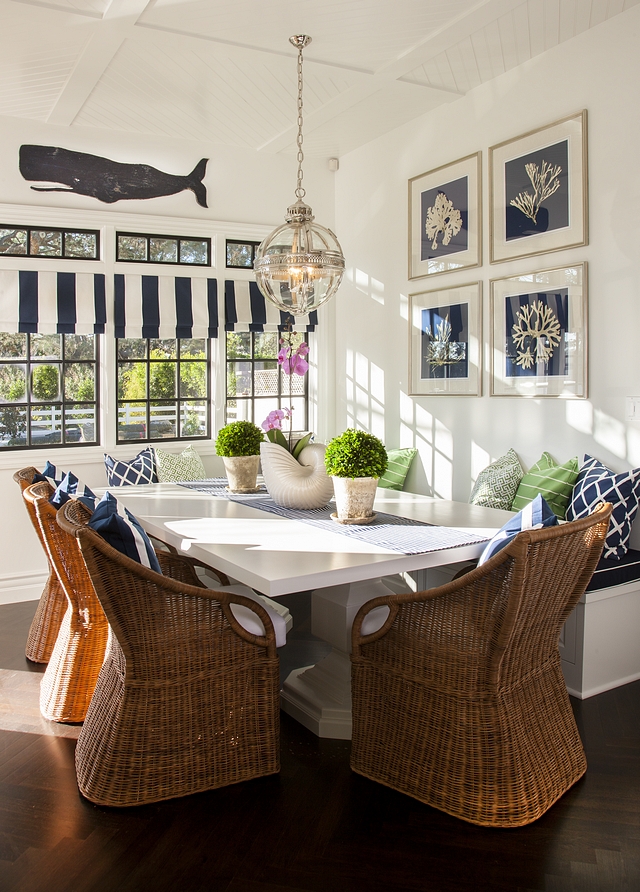 Coastal Breakfast nook Coastal Breakfast nook with wicker dining chairs and a white dining table complemented by a custom banquette Coastal Homes Coastal Interior Design #coastalbreakfastnook #coastalhomes #coastalinteriors #banquette #whitediningtable #wickerdiningchair