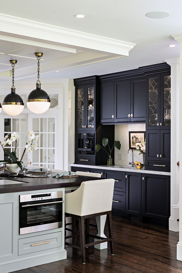 Brass hardware compliments the brass detail of the chandeliers over the island, while the matte black of the same chandeliers comes full circle back to the matte black of the coffee bar #kitchen #blackcabinet #mattecabinet #blackkitchen