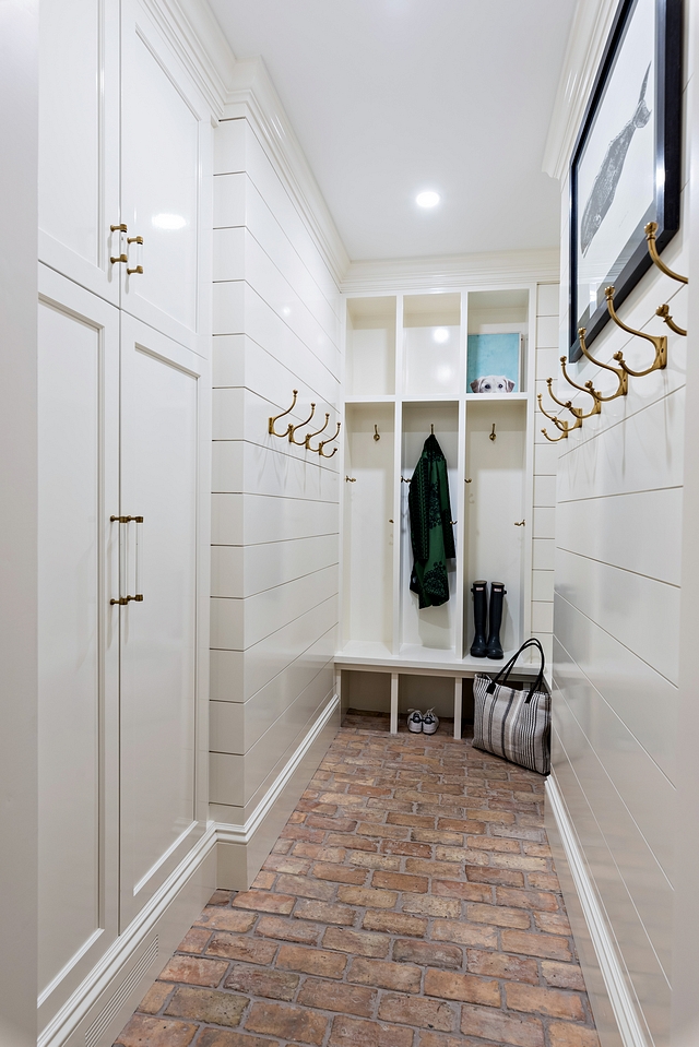 The new mudroom is wrapped in shiplap finished in a high-gloss white paint color, White Dove by Benjamin Moore, and it includes cubbies, and hooks. Tall cabinet hides return air duct White Dove by Benjamin Moore White Dove by Benjamin Moore #shiplap #WhiteDoveBenjaminMoore #highgloss
