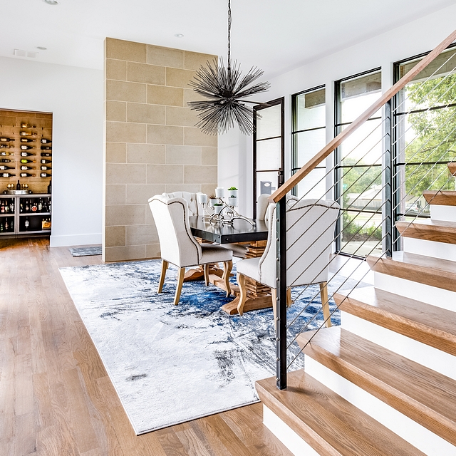 Concrete Tile Accent Wall Foyer Wall An accent wall, featuring a sleek concrete tile, creates a division from the foyer and the dining room. Ahead, you see a bar featuring grey cabinetry and the same concrete tile #concretetile 3foyer #accentwall #diningroom