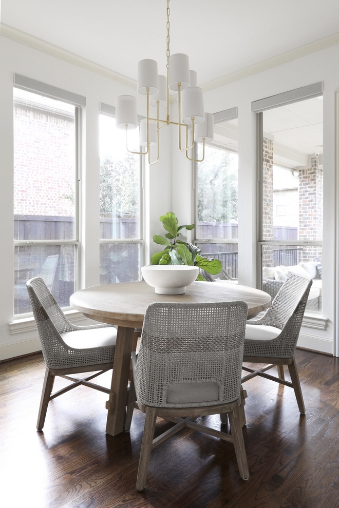 Breakfast Room Windows bring in plenty of natural light and a round dining table eases the flow between the kitchen and the back porch