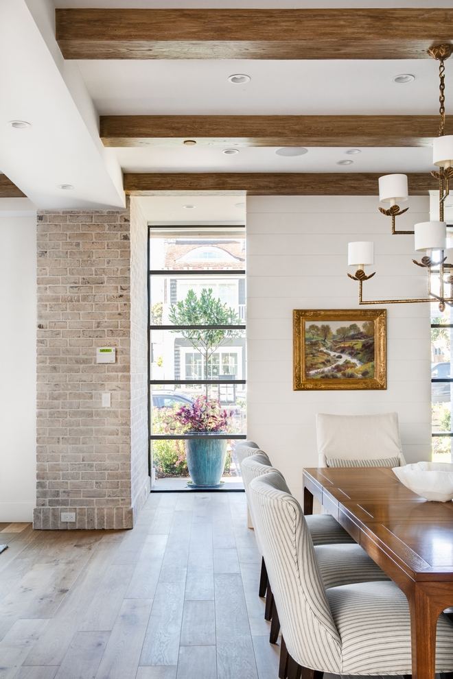 Whitewashed-brick- along-with-a wall-clad-in-shiplap-accentuates-the-Foyer-and-creates-some-privacy-to-the-rest-of-the-house